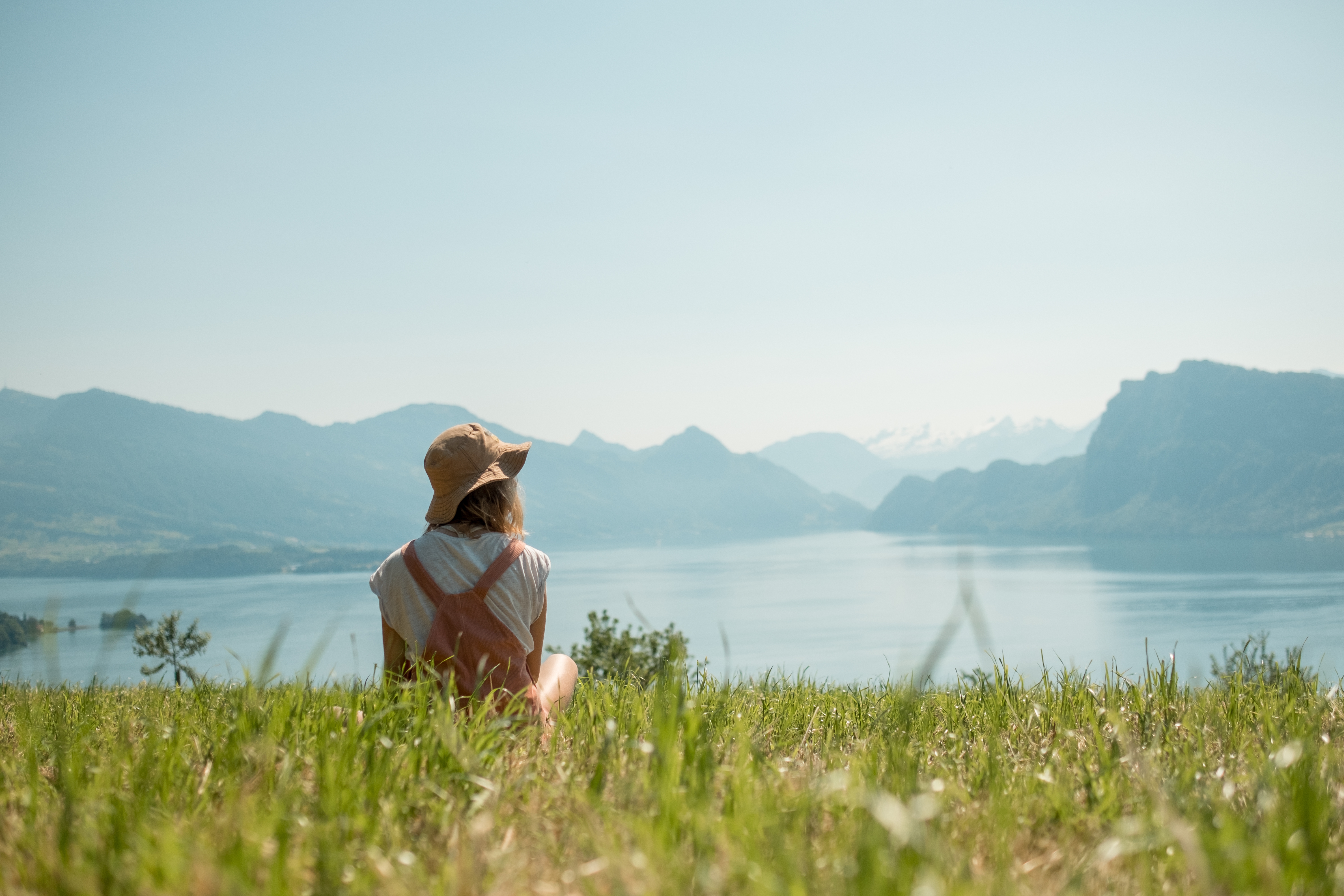 girl with had sitting green lawn near lake