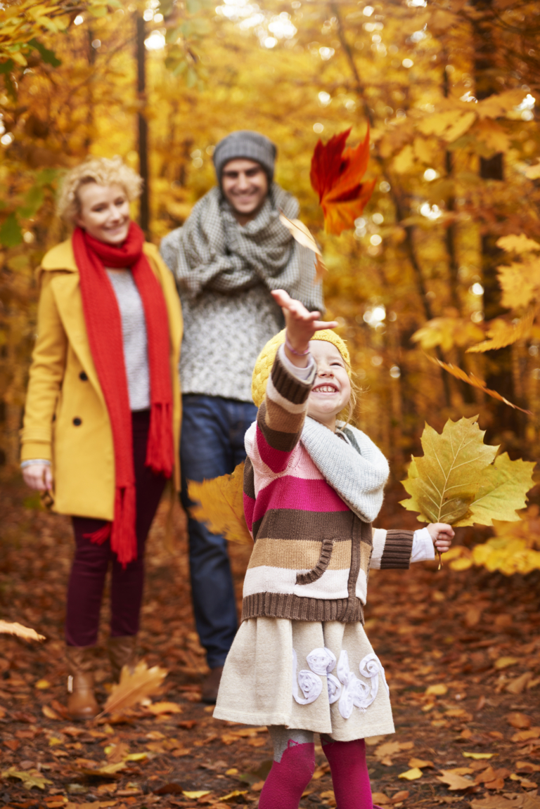 little girl playing with autumn leafs